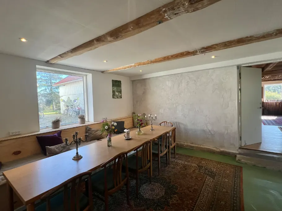 Langbord med stole og bænk langs vinduet i spisestuen.